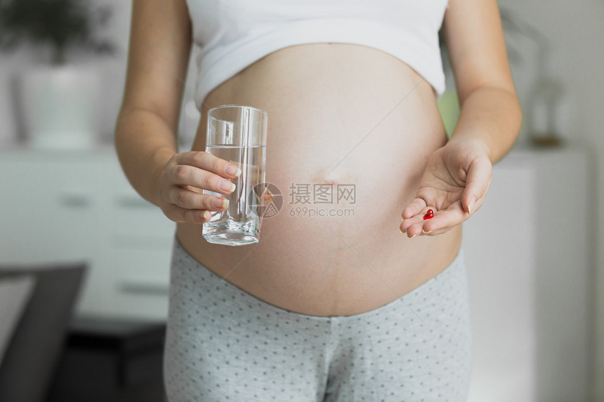 孕妇用水杯和药丸给孕妇图片