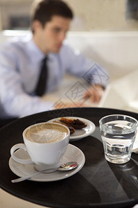 女服务员把咖啡和水端在托图片