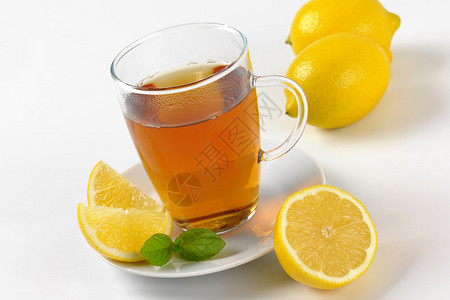 玻璃杯中的热茶和新鲜柠檬图片