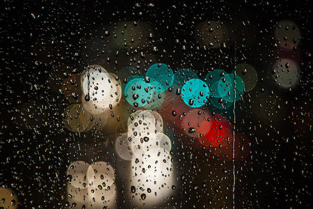 带有交通散景灯的窗户上的雨滴图片