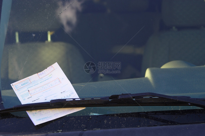一张爱车罚单被放在挡风玻璃底部的图片