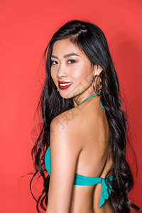一个微笑着的亚洲女人的肖像穿着绿色泳衣半翻背景图片