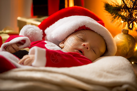 在的圣诞公帽中睡觉的婴儿男图片
