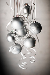灰色圣诞节球在孤立于灰色的丝带上背景图片