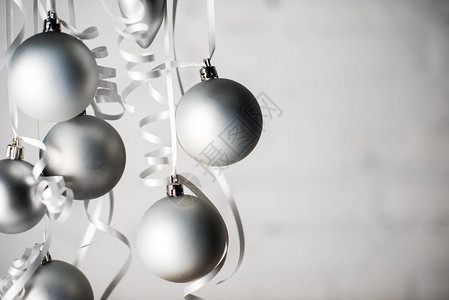灰色圣诞节球在孤立于灰色的丝带上背景图片