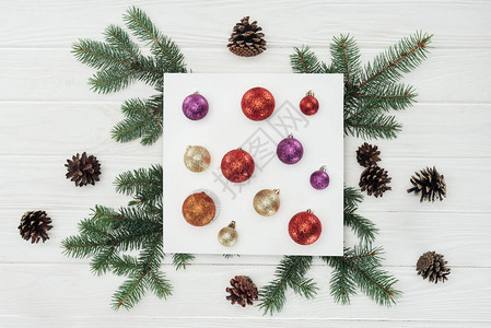 白色卡片上闪亮多彩的圣诞节球木面上图片