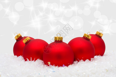 红圣诞装饰品在雪上有银本底的雪背景图片