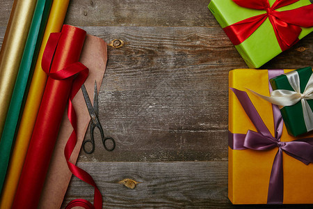 包装纸新年赠品以及木制桌面上带丝和剪背景图片