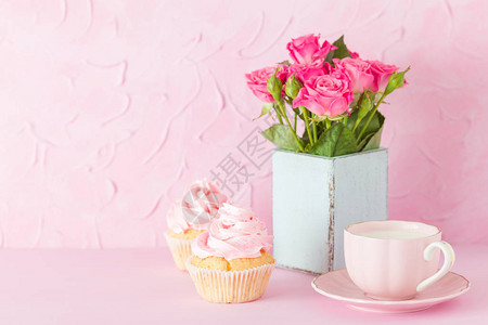 装饰着纸杯蛋糕一杯牛奶咖啡和一束粉红玫瑰图片