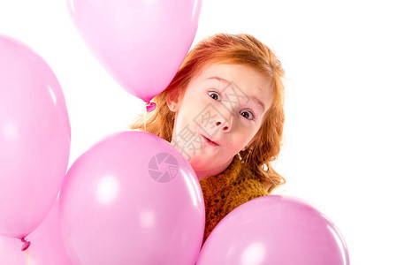 赤红的发孩子站着带着一捆粉色气球图片