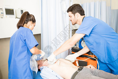急救医疗队对一名无意识男病人进行心脏按摩图片