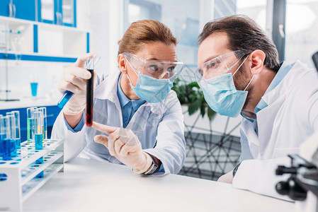 使用实验室试剂的科学家用白外套和医疗图片