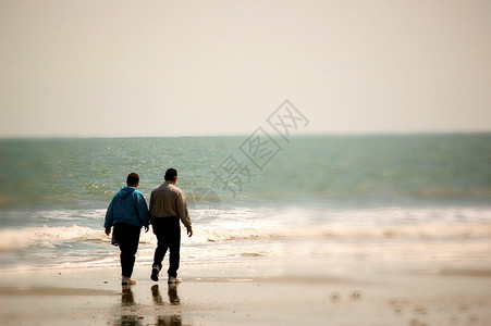 老年夫妇在沙滩上散步背景图片