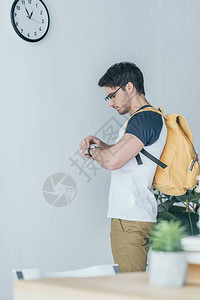 背着包看手表的英俊男学生图片