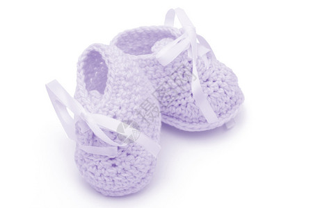 在白色手工制婴儿鞋上隔离的紫色图片