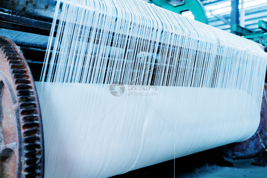 一排纺织机在纺织厂编织棉纱图片