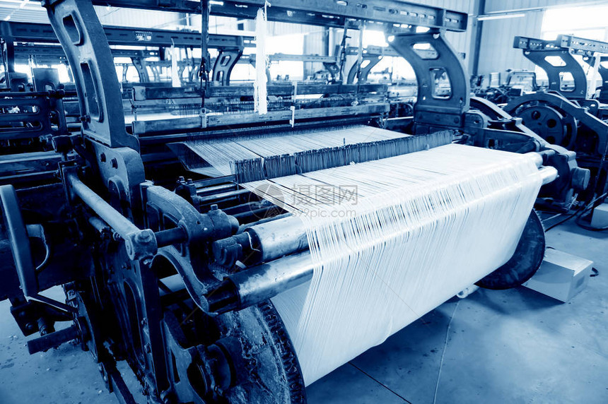 一排纺织机在纺织厂编织棉纱图片