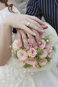 结婚戒指和配有花束的夫妇图片