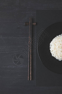黑桌上米饭和筷子的俯视图图片