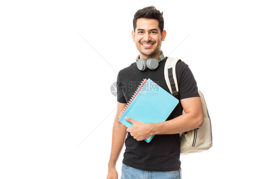 带着书本和背包的白背景年轻大学生笑