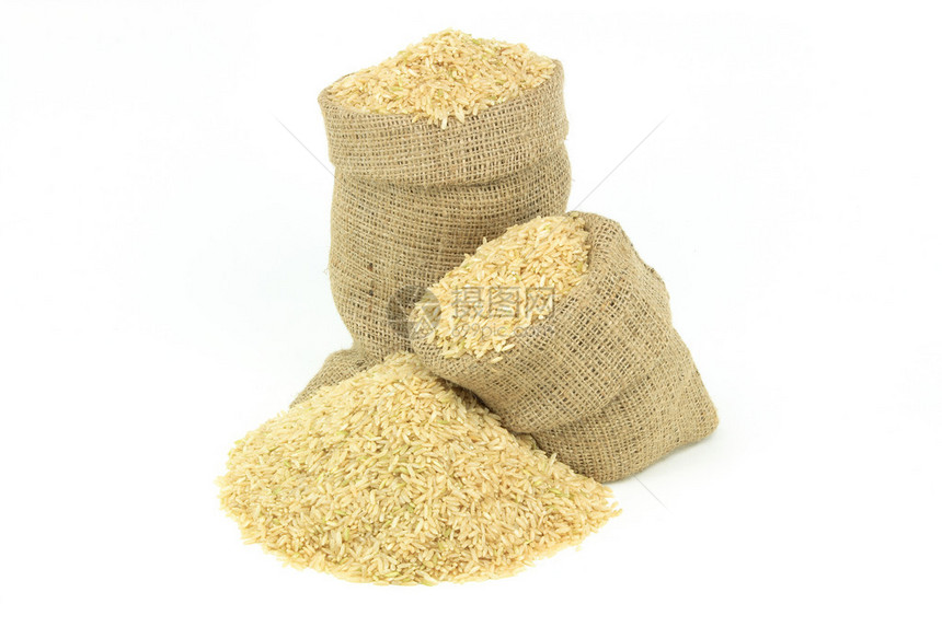 照片上仍展示着棕色大米洒在堆积物上和白背景图片