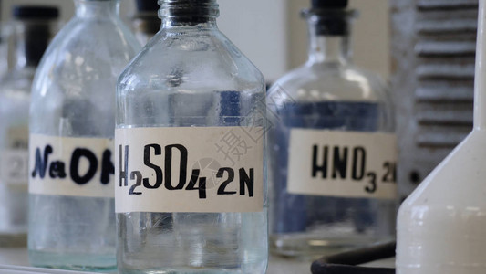 瓶溶液储存在实验室的架子上装有NaOHH2so4和HNO3化学溶液的瓶子硫酸氢背景图片