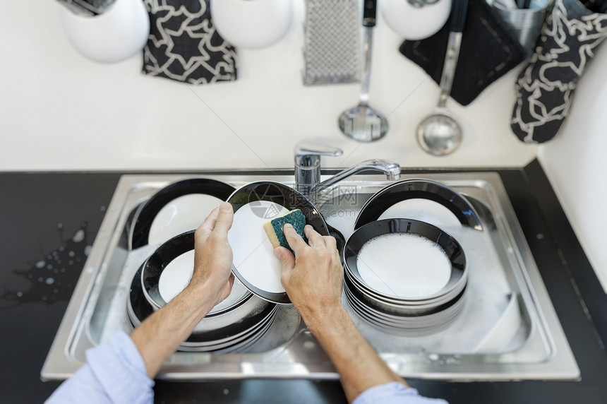 厨房里清洗盘子的人图片