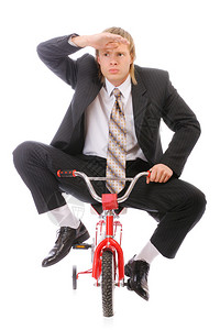 商人骑着儿童自行车在白色背图片