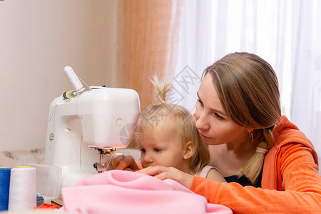 妇女在家里缝衣服向自己的小孩子图片
