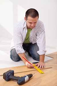 铺设复合地板的人测量木板图片
