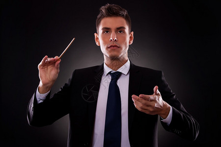 指挥他的管弦乐队的年轻指挥家的画像领导理念年轻的商人图片