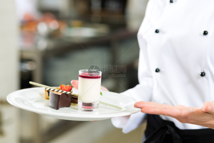 厨师女糕点师在酒店或餐厅厨房做饭她图片