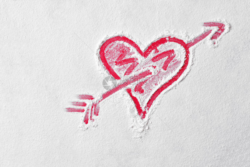 红板上的面粉中带有丘比特箭头的心形爱情标志图片