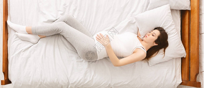 疲惫的孕妇躺在床上图片