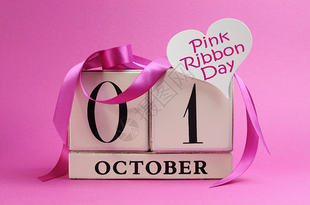 将10月1日粉红丝带日的期白色日历标记为粉红色背景上的粉背景图片