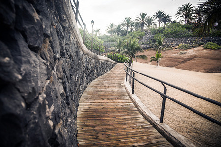 沿海滩石墙的木人行道图片