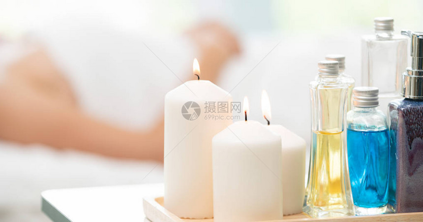 治疗套装包括按摩床上的芳香按摩油润肤露蜡烛和草药提取物图片