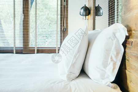 室内卧室轻光过滤器和选择焦点的床上装饰中的白图片