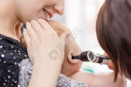 医生用耳镜检查孩子的耳朵妈用手抱着婴儿童保健和图片