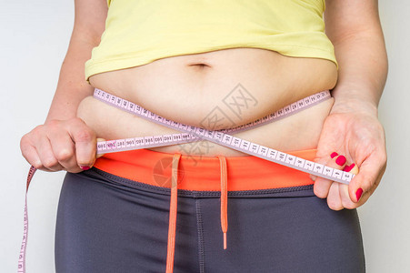 带胶的超重女人测量肚子脂肪图片