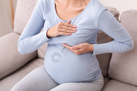 乳腺病无法辨认的孕妇在家中沙发上躺在沙发上背景