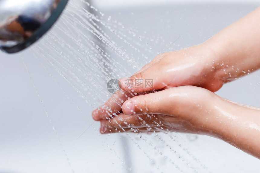 小孩子用肥皂和水洗手的细节图片