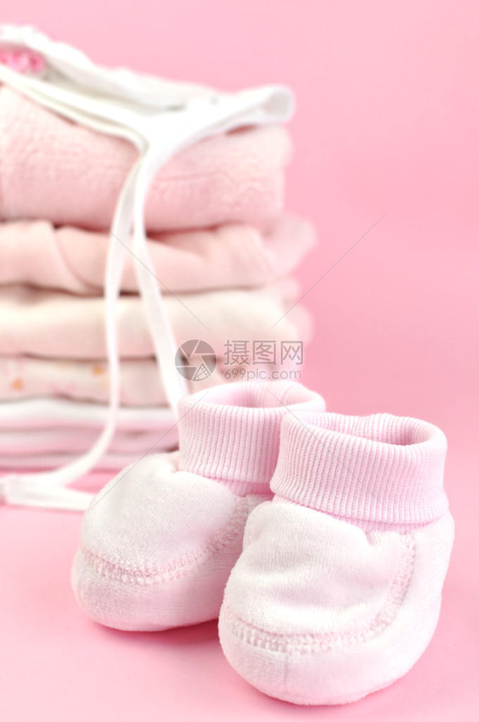 短靴和一堆粉红色的婴儿衣物图片
