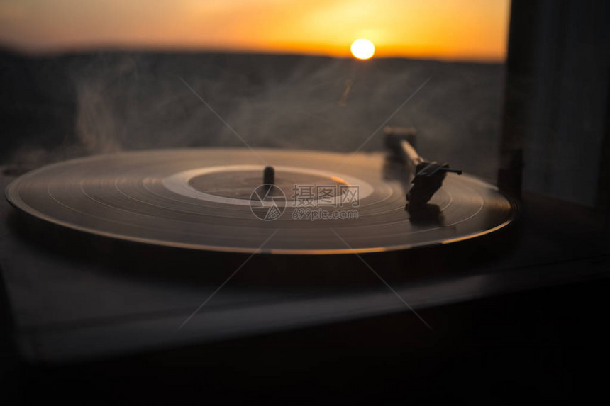 在山上日落的上的转盘黑胶唱片播放器DJ混合和播放音乐的声音技术胶唱片老式黑胶唱片播放器黑图片