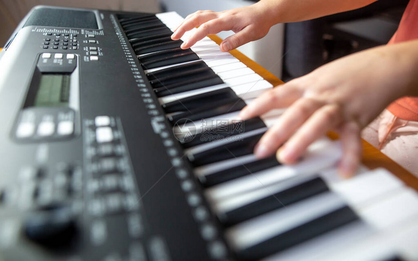 年轻女初学者教自己玩电钢琴演图片