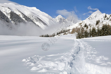 穿越高山的雪中小路图片