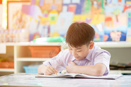 快乐的亚洲孩子写书面带微笑的脸在图片