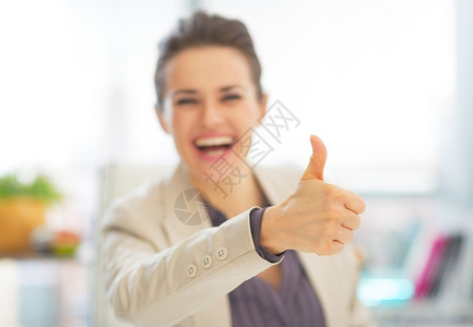 微笑的女商人竖起大拇指的特写图片