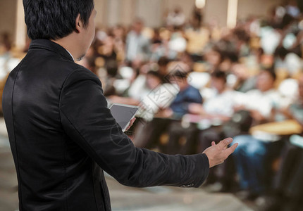 商务人士会议发言人的后视图在会议厅或研讨室的抽象模糊照片上图片