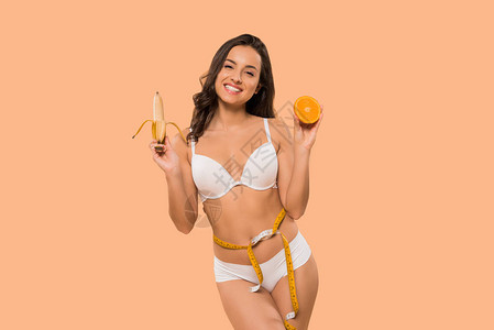 开心的女人拿着香蕉和橘子在图片